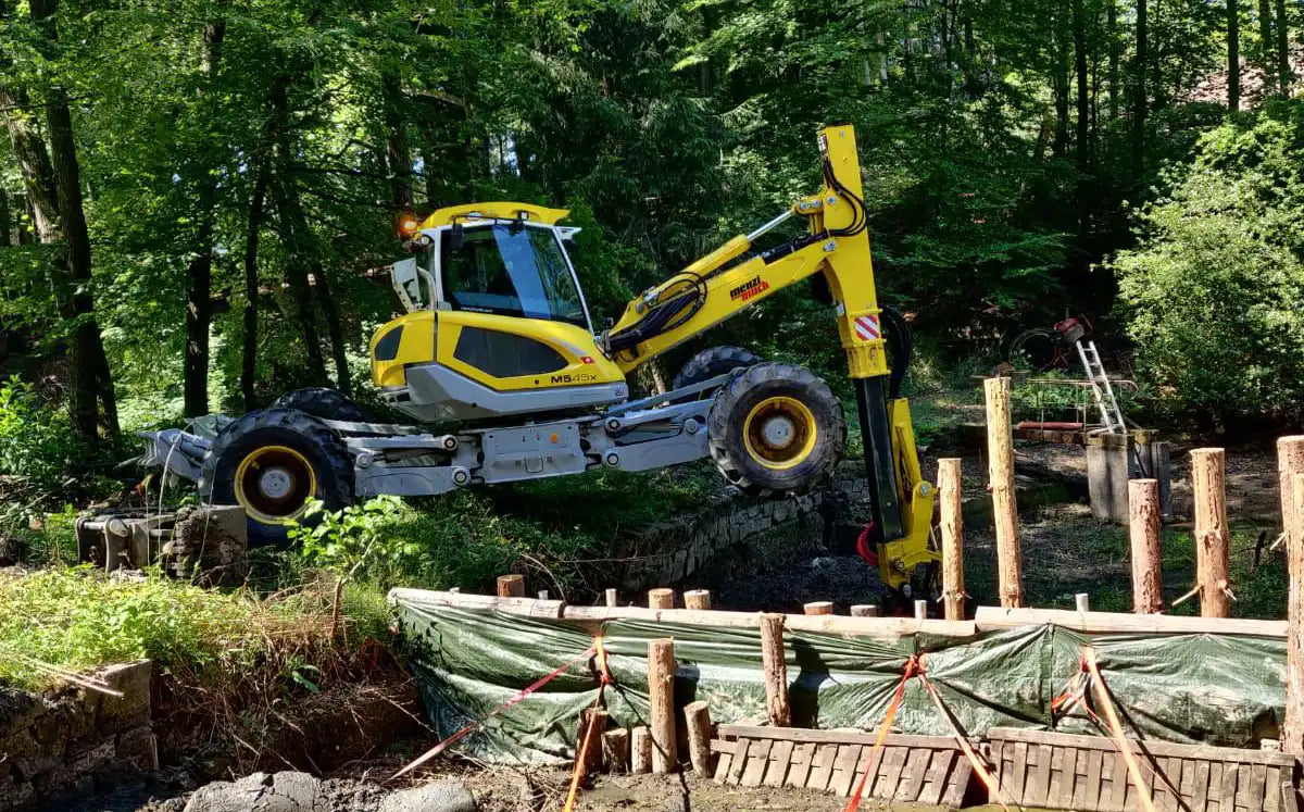 Menzi Muck klettert in leeren Teich – Referenzbild in der Kategorie Teicharbeiten