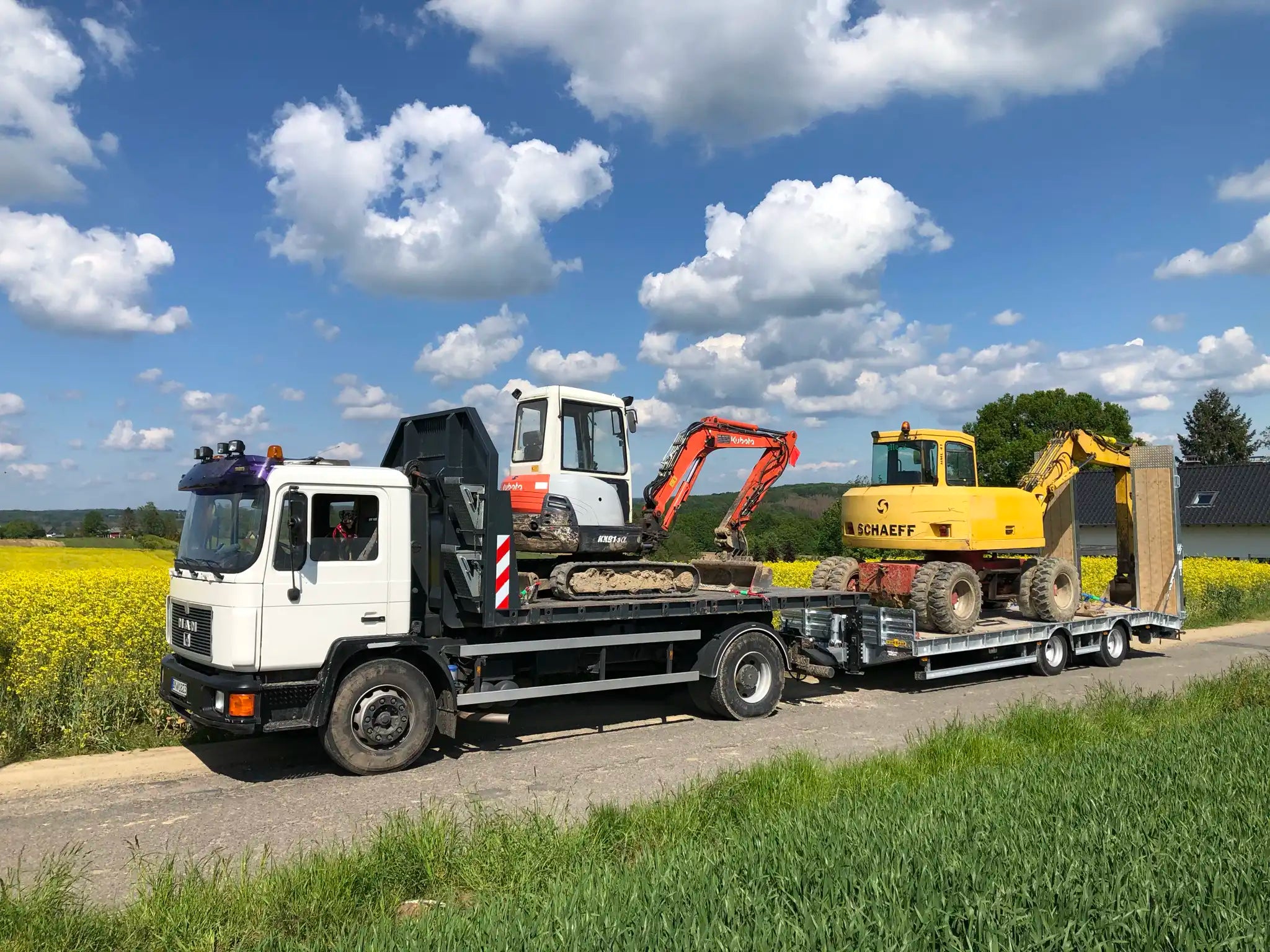 Zwei Bagger auf LKW mit Anhänger – Referenzbild in der Kategorie Baggerabeiten