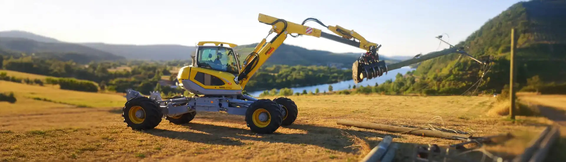 Menzi Muck transportiert Freileitungsmast – Banner zur Kategorie Freileitungsarbeiten