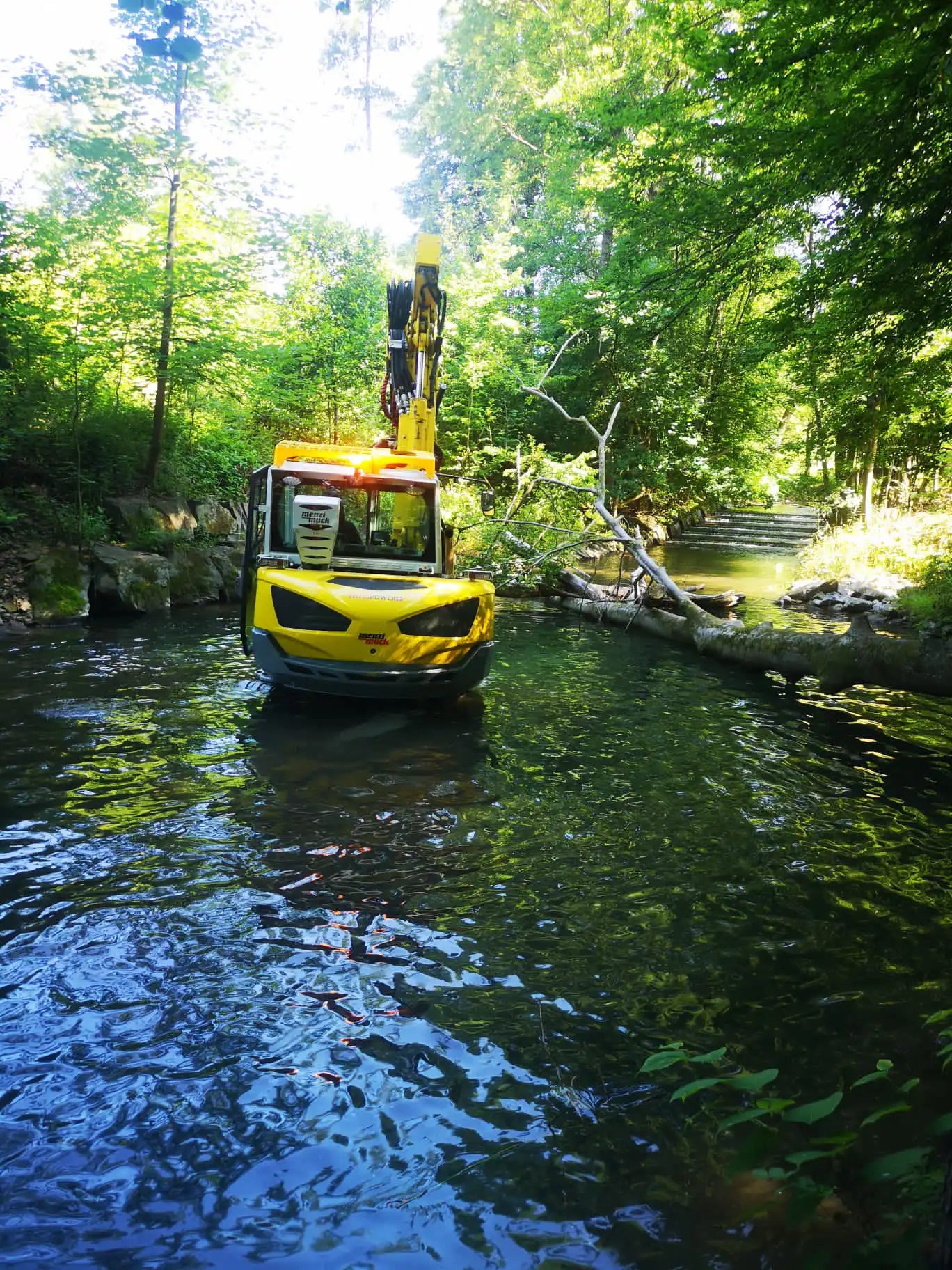 Menzi Muck bis zum Fahrerhaus im Wasser – Referenzbild in der Kategorie Gewässerarbeiten